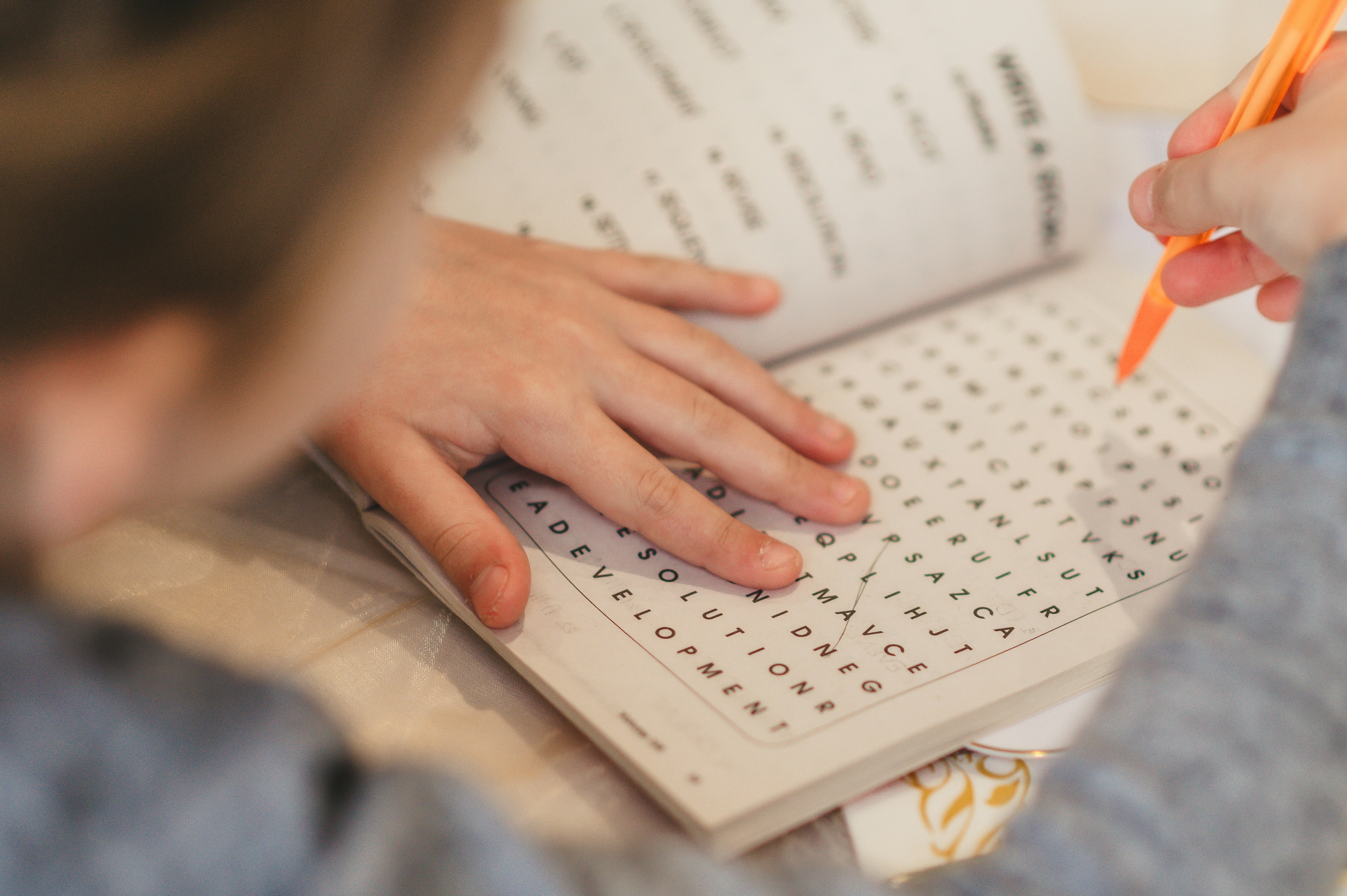 Image of person doing a find the word puzzle.
